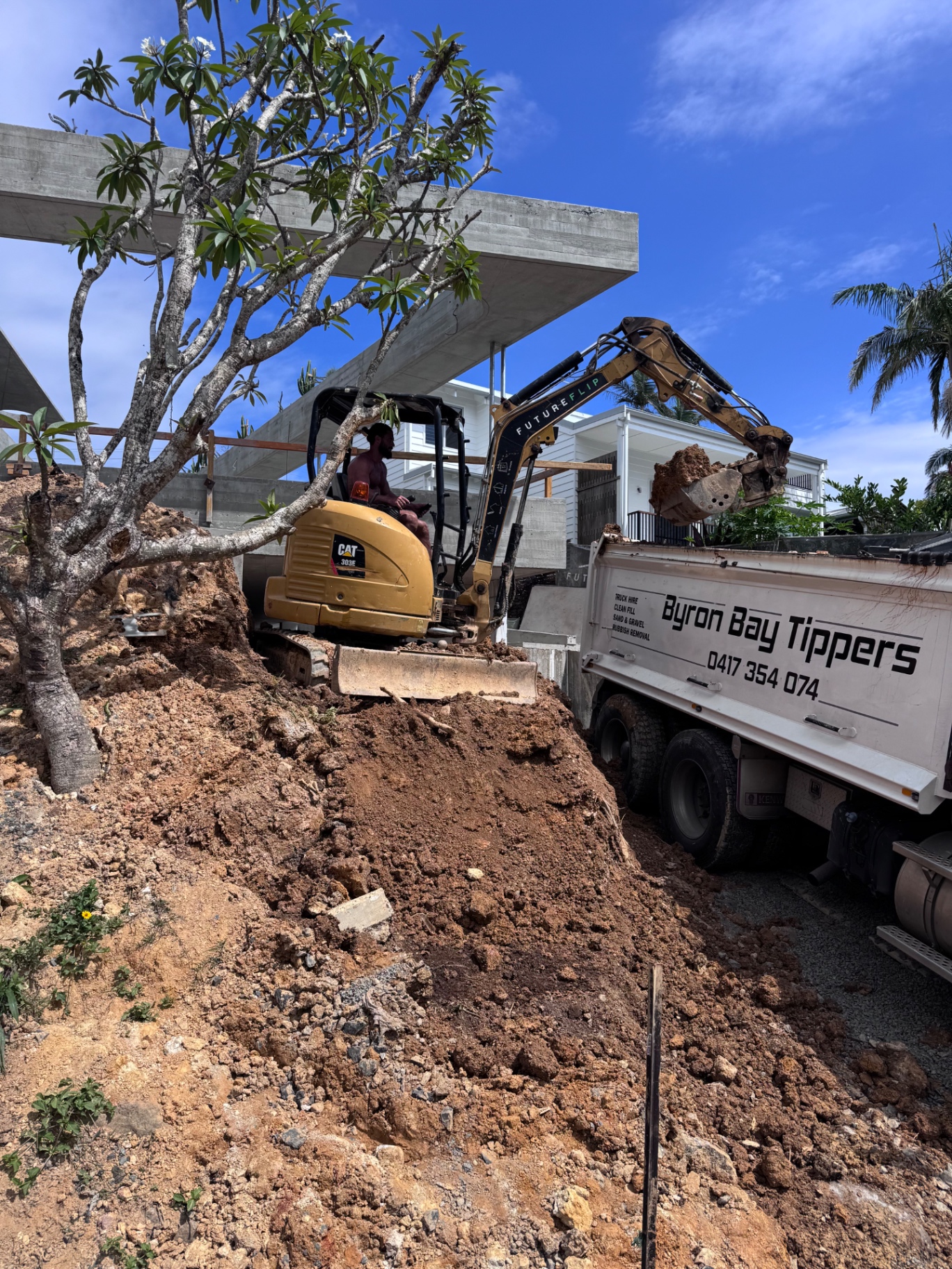 Excavator loading Byron Bay Tippers truck at a residential job site